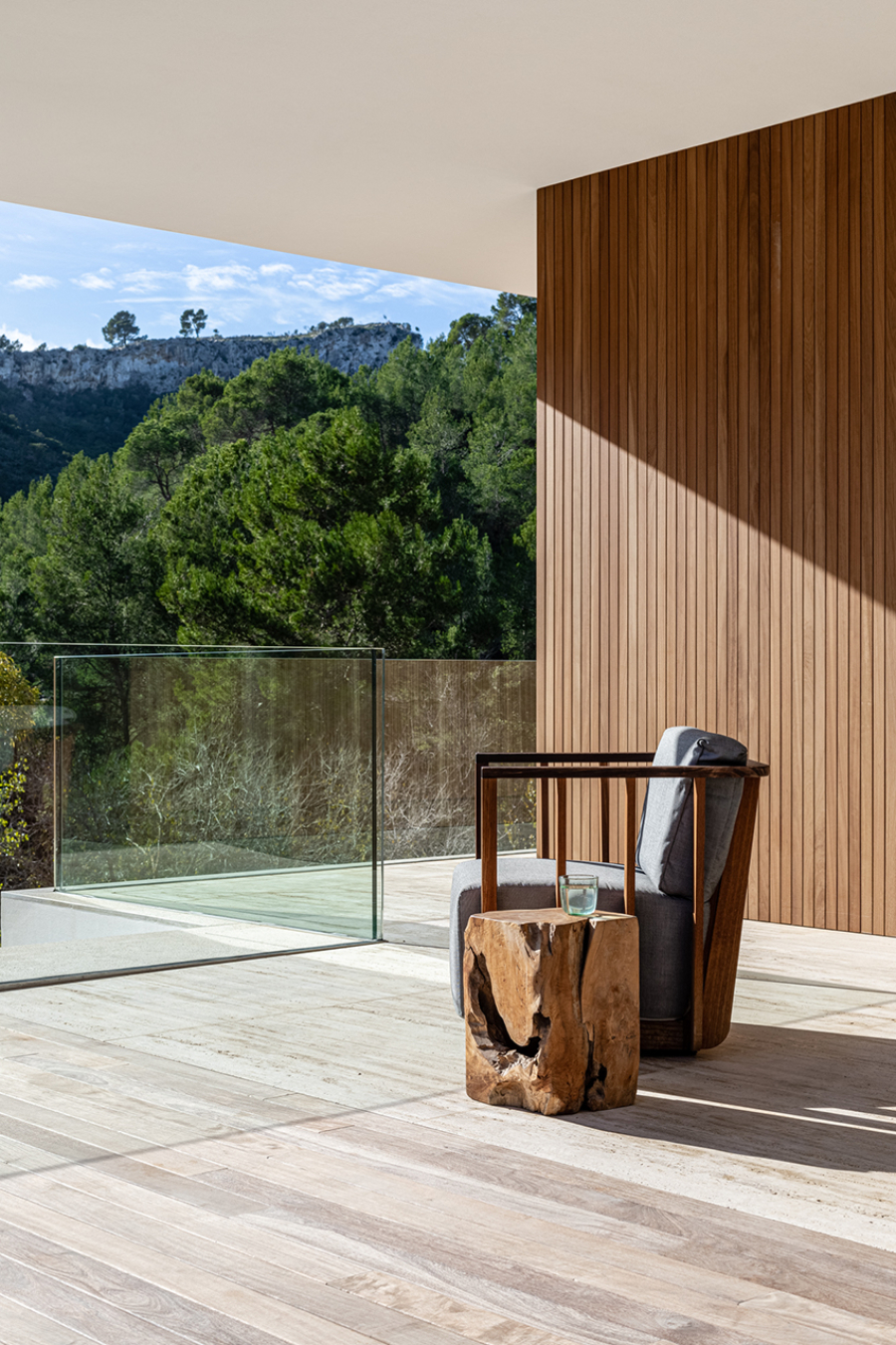 Balcony by Jorge Bibiloni Studio with a comfortable armchair and wooden side table