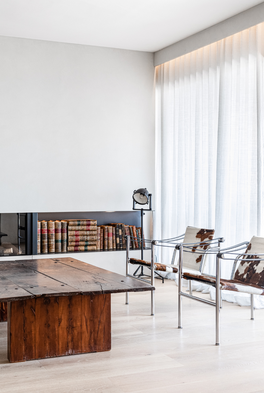 living room by Jorge Bibiloni Studio with wooden table and leather armchairs