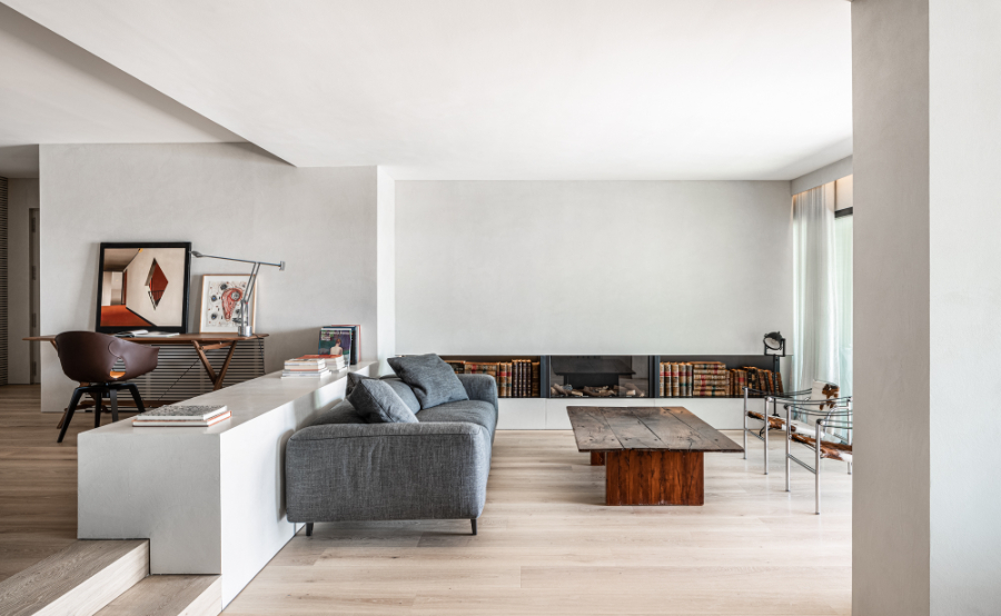 living room by Jorge Bibiloni Studio with grey sofa and wooden rectangular table