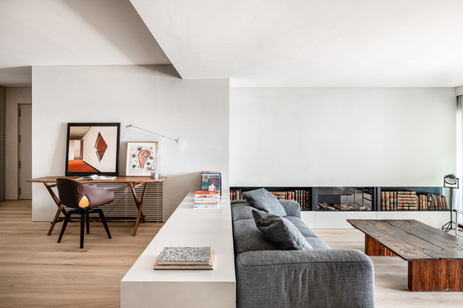living room by Jorge Bibiloni Studio with grey sofa and wooden tables