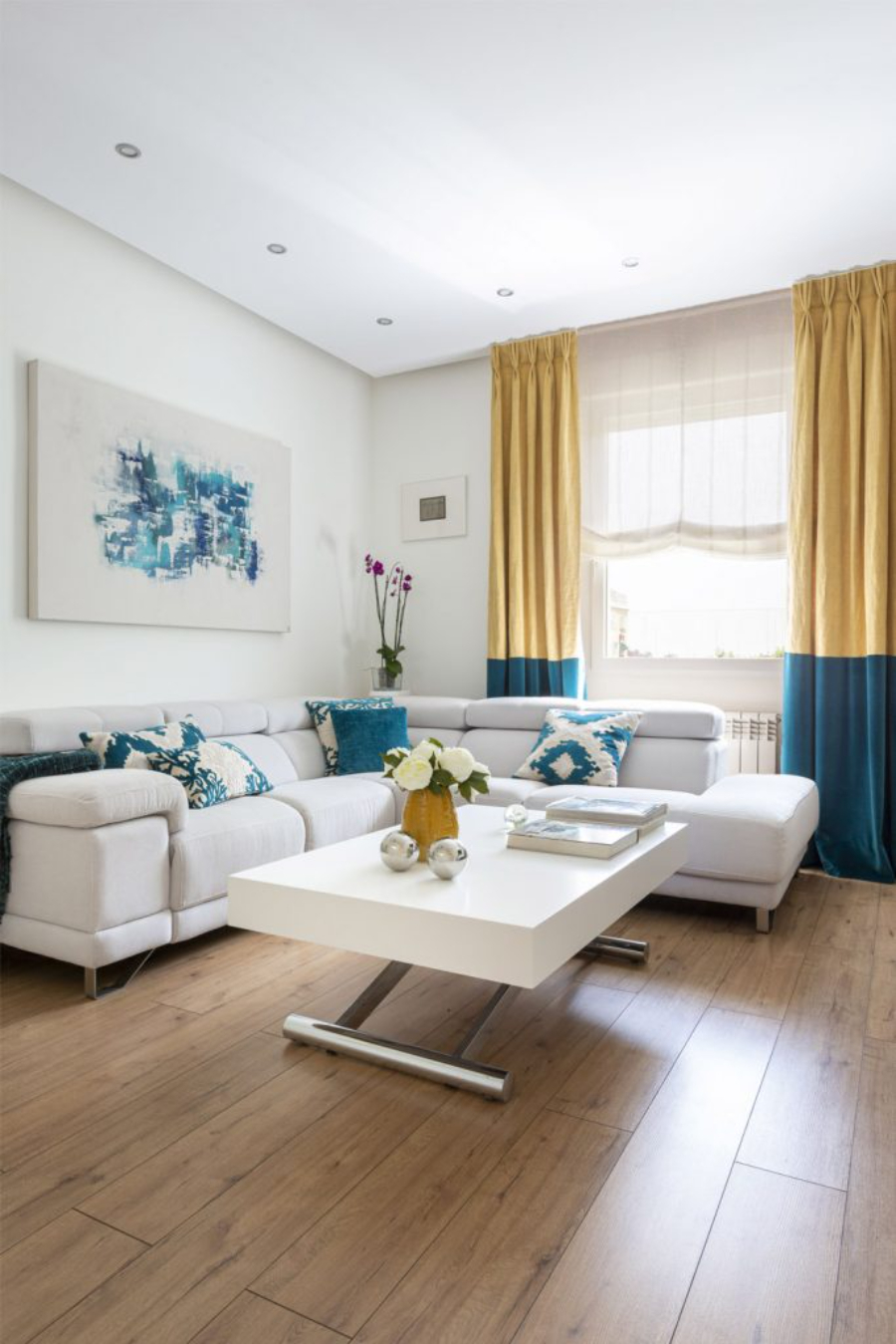 Living room by Mercedes Arce with white sofa and white coffee table